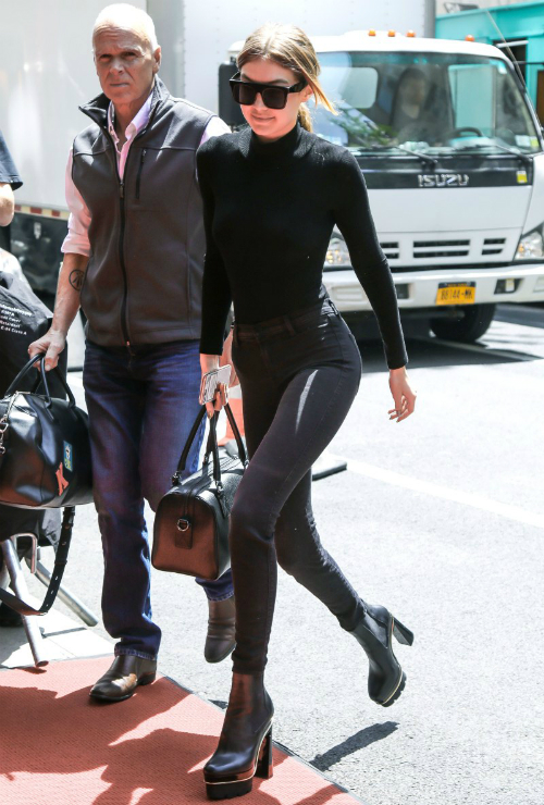 Gigi khoe body chuẩn không cần chỉnh với cây đen từ đầu đến chân: skinny jeans J Brand, boot Versace boots và kính mát Vera Wang tông xuyệt tông.