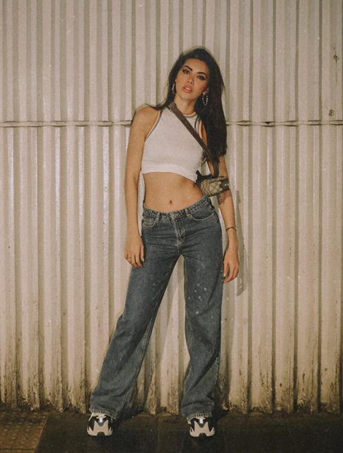 Minh Tú hưởng ứng thời trang những năm 2000 khi đi du lịch Thái Lan. Cô nàng khoe eo thon với croptop và quần jeans cạp trễ.