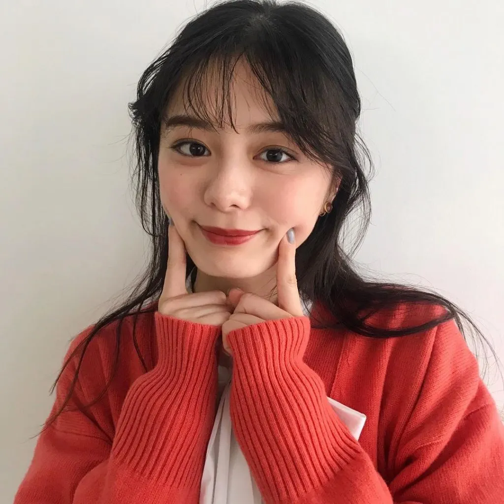 cô gái chống hai ngón tay lên má